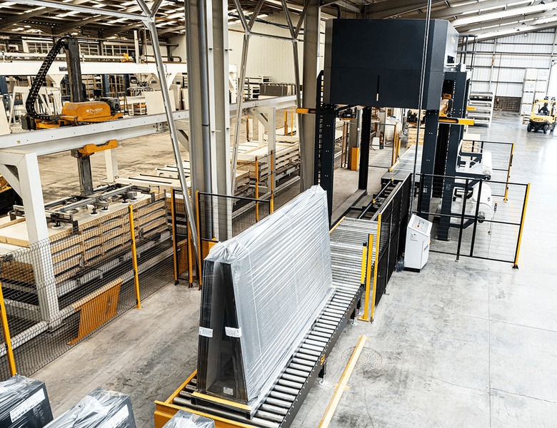 Long pallet of goods with stretch hooder film moving along a conveyor